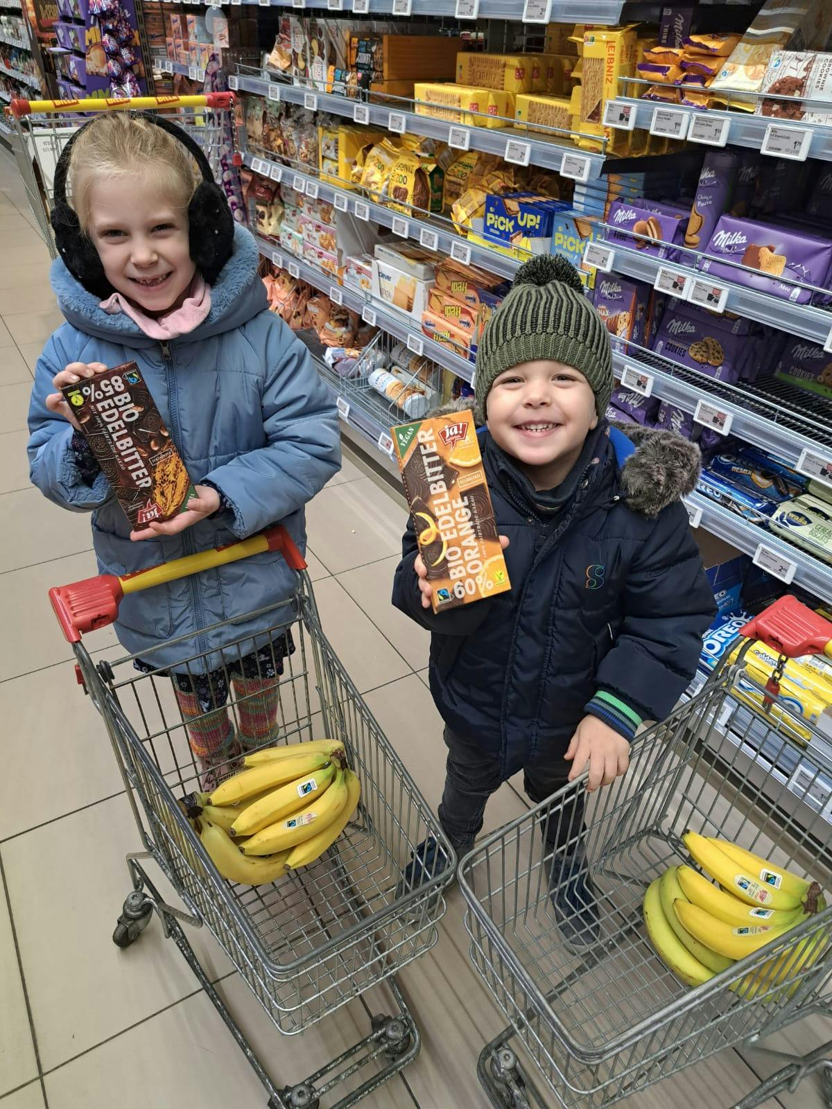 Zwei Kinder kaufen die Zutaten für die Bananenmuffins, welche im Kindergarten Frauental mit den Kindern gebacken wurden.